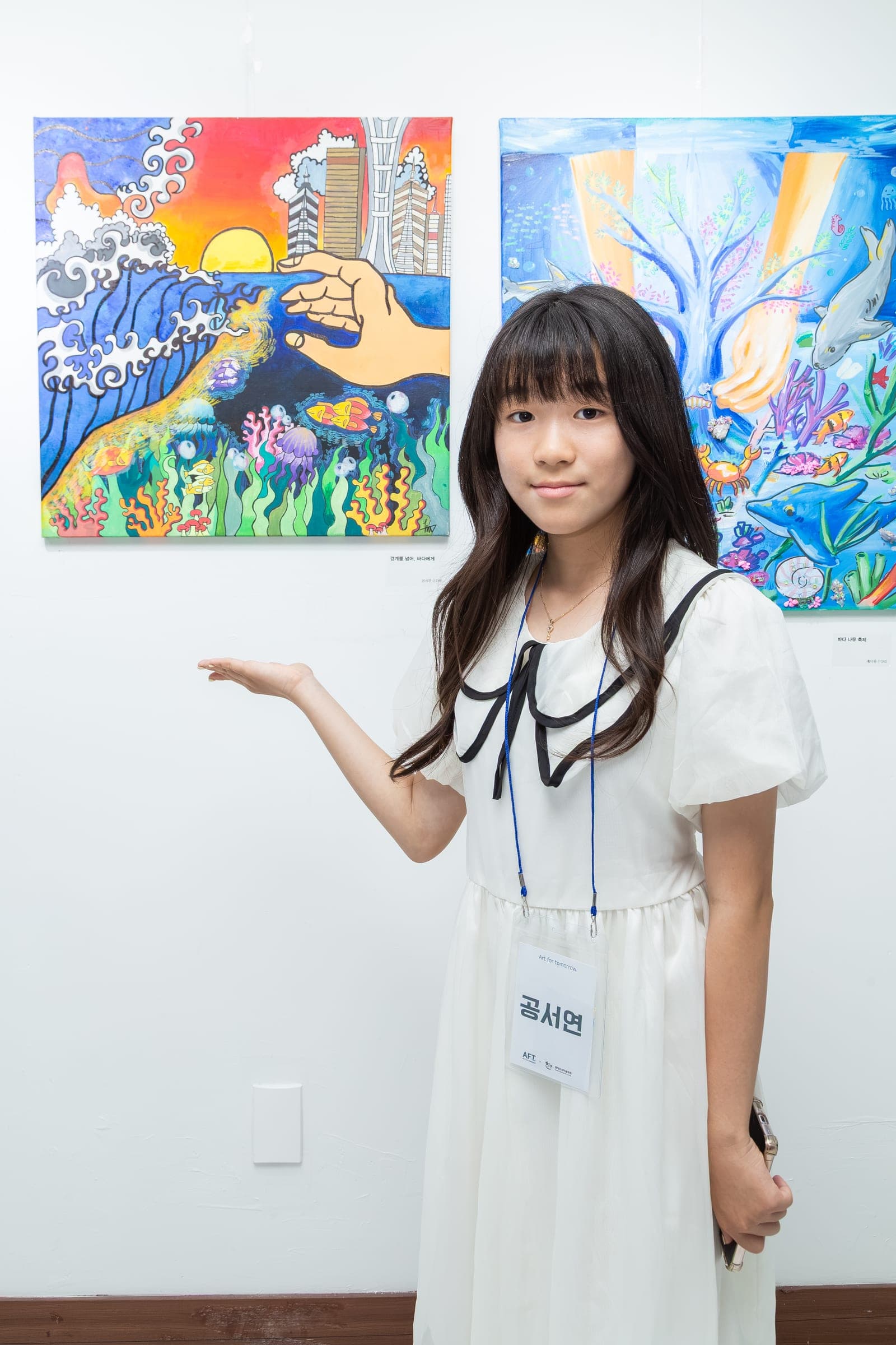 Young artist beside their ocean-themed artwork